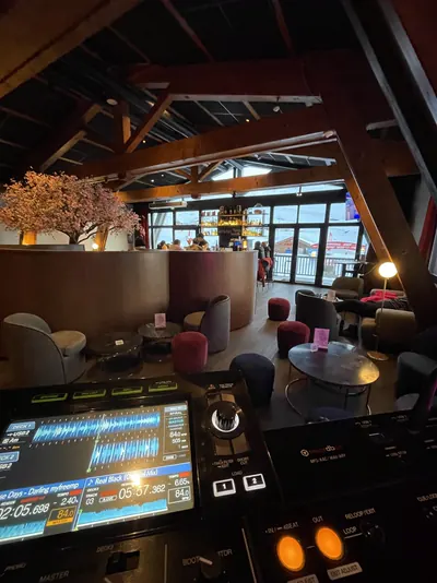 Mixing desk facing the lounge of a mountain bar, timber roof