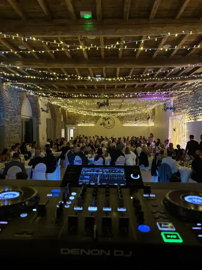 DJ booth facing a wedding hall under string lights